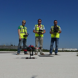 photo de trois hommes ne habille de chantier et un drone noir